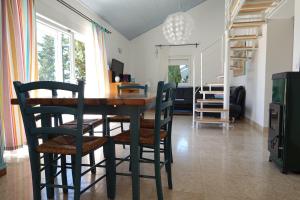 comedor con mesa de madera y sillas en Vila Paula 6+1 en Rab