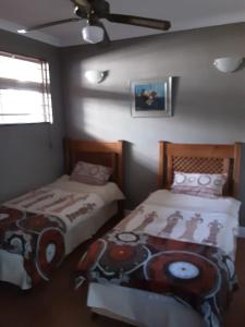 a bedroom with two beds and a ceiling fan at Margate, Granada 102 in Margate