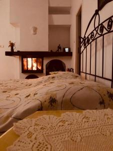 a bedroom with a large bed with a fireplace at Dworek Mazurski Ruś in Ruś