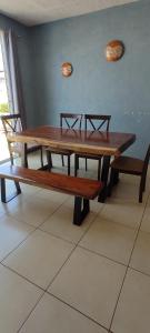 a wooden table and benches in a room at Departamento completo en Marina Diamante in Acapulco