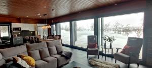 a living room with a couch and a large window at Villa Kammi Kilpisjärvi in Kilpisjärvi