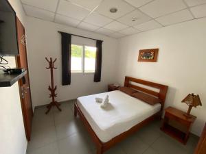 una camera da letto con un letto con una croce sopra di Hotel Ummagumma a Montañita
