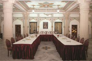 Cette grande chambre comprend une grande table et des chaises. dans l'établissement Jagat Palace, à Pushkar