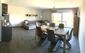 a dining room and living room with a table and chairs at Haus Kranichfeld Wohnung S in Dranske