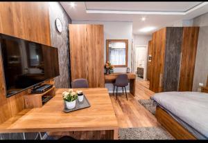 Zimmer mit einem Bett und einem Tisch mit einem TV in der Unterkunft Ivi Place Apartments in Novi Sad