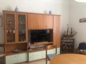 a large wooden entertainment center with a flat screen tv at Fronte Mare in Albissola Marina