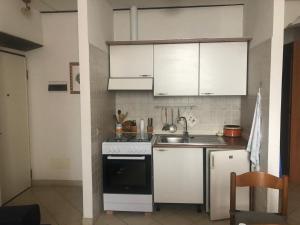 a kitchen with white cabinets and a sink and a stove at Fronte Mare in Albissola Marina