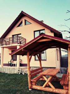 a house with a wooden pergola in front of it at Casa Lalelelor in Râşnov