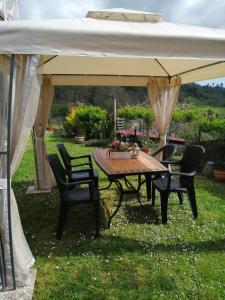 a table and chairs under a white umbrella at Casa Lilly in Beverino