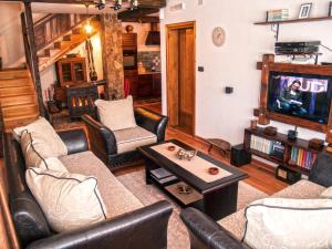 a living room with leather furniture and a tv at Holiday Home Drijenak in Kolašin