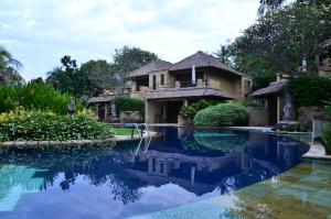 a house with a swimming pool in front of it at Pool Villa Merumatta Senggigi in Senggigi
