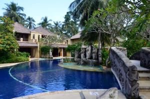 a swimming pool in front of a house at Pool Villa Merumatta Senggigi in Senggigi