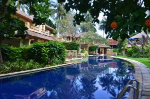 a swimming pool in front of a house at Pool Villa Merumatta Senggigi in Senggigi