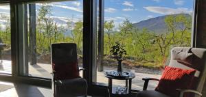 Una habitación con dos sillas y una mesa y una ventana. en Villa Kammi Kilpisjärvi, en Kilpisjärvi