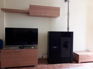 a living room with a flat screen tv and a entertainment center at La Casa de la Callejuela in Riaza