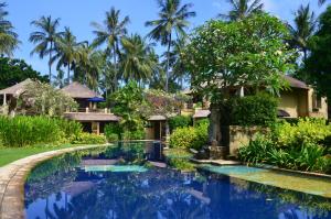 a villa with a swimming pool in front of a resort at Pool Villa Merumatta Senggigi in Senggigi