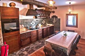 a large kitchen with a table and a stove at Holiday Home Drijenak in Kolašin