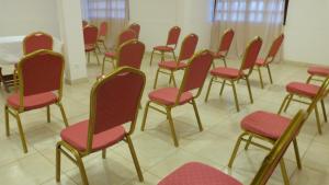 a row of chairs with red seats in a room at Hotel Madou Grand Bassam in Grand-Bassam
