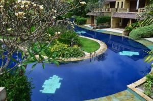 a swimming pool with blue water in a yard at Pool Villa Merumatta Senggigi in Senggigi