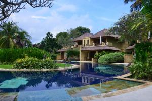 a villa with a swimming pool in front of a house at Pool Villa Merumatta Senggigi in Senggigi