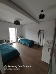 a bedroom with two beds and a window at Apartament Mszana Dolna in Mszana Dolna