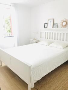een wit bed met witte lakens en kussens bij Casa da Ilha in Madalena