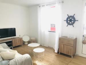 a living room with a couch and a tv at Casa da Ilha in Madalena