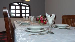 - une table avec des assiettes, des verres et des fleurs dans l'établissement Hotel Madou Grand Bassam, à Grand-Bassam