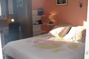 a bedroom with a bed and a desk with a lamp at La Vie Au Roze in Quéven