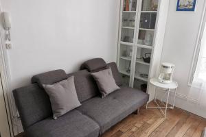 a couch with two pillows in a living room at Wei&Pei Apartment - Hypter Center St Germain En Laye 1min RER in Saint-Germain-en-Laye