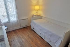 1 dormitorio con 1 cama y 1 lámpara en el suelo en Wei&Pei Apartment - Hypter Center St Germain En Laye 1min RER en Saint-Germain-en-Laye