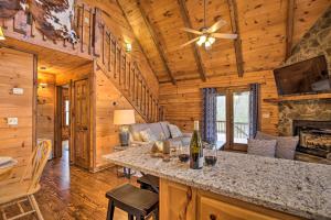a log cabin living room with a bar and a fireplace at Picturesque Mountain Cabin with Hot Tub and Fire Pit! in Blue Ridge