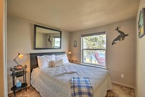 ヴァルドポートにあるWaldport Beach House with Loft, Grill and Ocean Views!のベッドと鏡と窓のある寝室