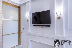 een flatscreen-tv aan een muur in een badkamer bij Suite Kintsugi by Justine Apartments Apartamento turístico en Madrid Río in Madrid