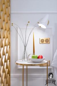 una mesa con un tazón de manzanas y un jarrón en ella en Suite Kintsugi by Justine Apartments Apartamento turístico en Madrid Río en Madrid