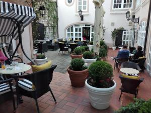an outdoor patio with tables and chairs and plants at Hotel Livadić in Samobor