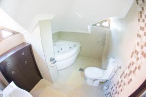 a bathroom with a toilet and a bath tub at Swiss Holiday Hotel by KUNDAKCI GROUP in Budva +41 photos