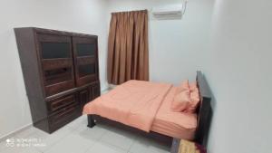 a small bedroom with a bed and a dresser at Maryam Homestay in Jertih