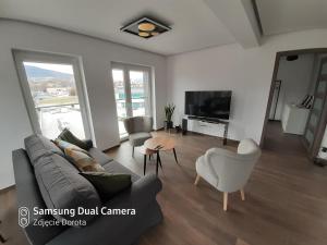 a living room with a couch and a tv at Apartament Mszana Dolna in Mszana Dolna