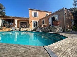 a swimming pool in front of a house at Le calme de la garrigue in Russan