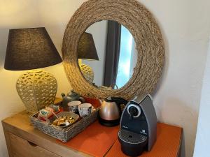 a table with a mirror and a lamp and a basket of food at Le calme de la garrigue in Russan