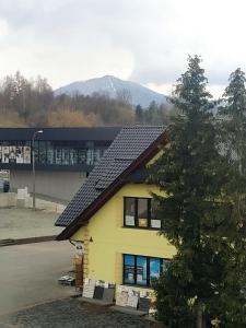 a yellow house with solar panels on its roof at Apartament Mszana Dolna in Mszana Dolna