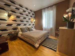 a bedroom with a bed with a checkered wall at Le calme de la garrigue in Russan