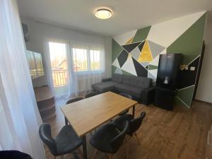 salon z drewnianym stołem i krzesłami w obiekcie Black Brothers Wellness Apartments w Siófoku