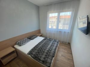 mała sypialnia z łóżkiem i oknem w obiekcie Black Brothers Wellness Apartments w Siófoku
