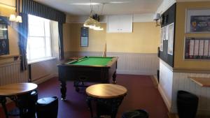 a pub with a pool table and some stools at The Swan Inn in Moreton in Marsh