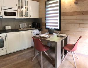 een keuken met een tafel en stoelen in een kamer bij Fanjeaux Aude Le Chalet in Fanjeaux