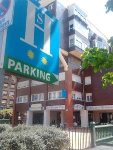 una señal de aparcamiento frente a un edificio en Hostal Rocamar, en Santander