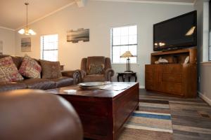 a living room with a couch and a flat screen tv at Lakefront Cottage with Private Hot Tub! in Buckhead