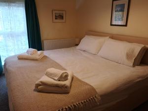 2 Bed Cottage Dog Child Friendly 15min walk to beach في Ederyn: غرفة نوم عليها سرير وفوط